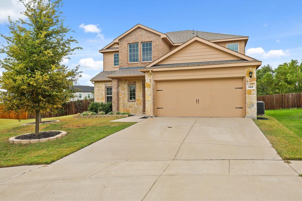 a front view of a house with a yard and a garage