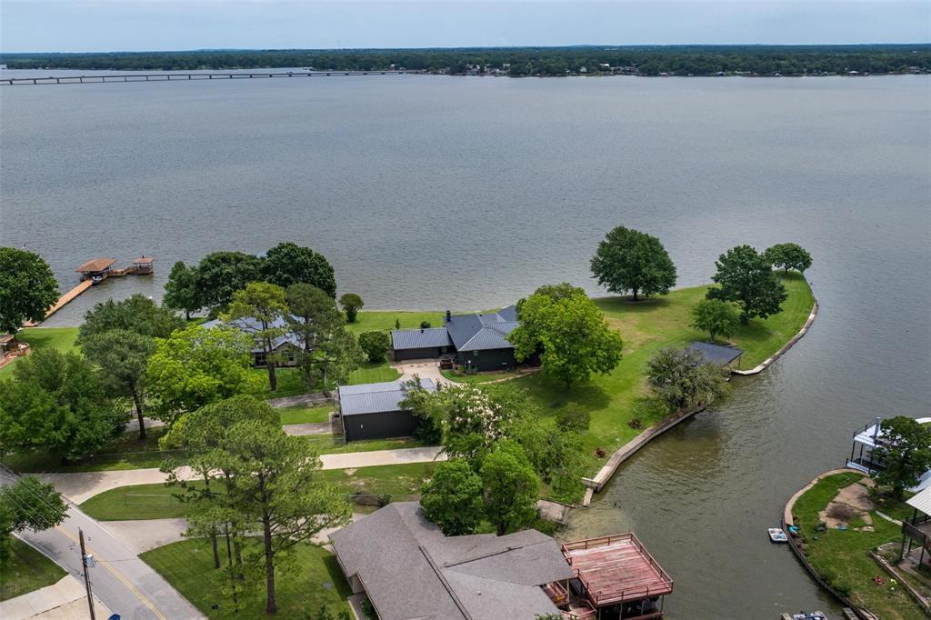 an aerial view of a house with a yard and lake view