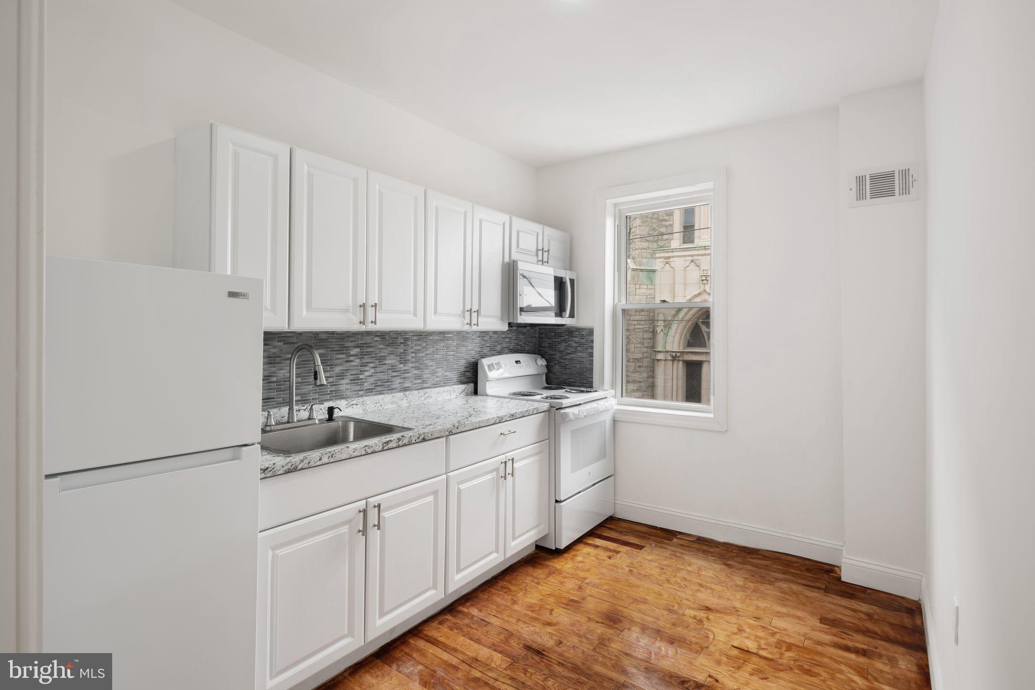 a kitchen with a sink cabinets and window