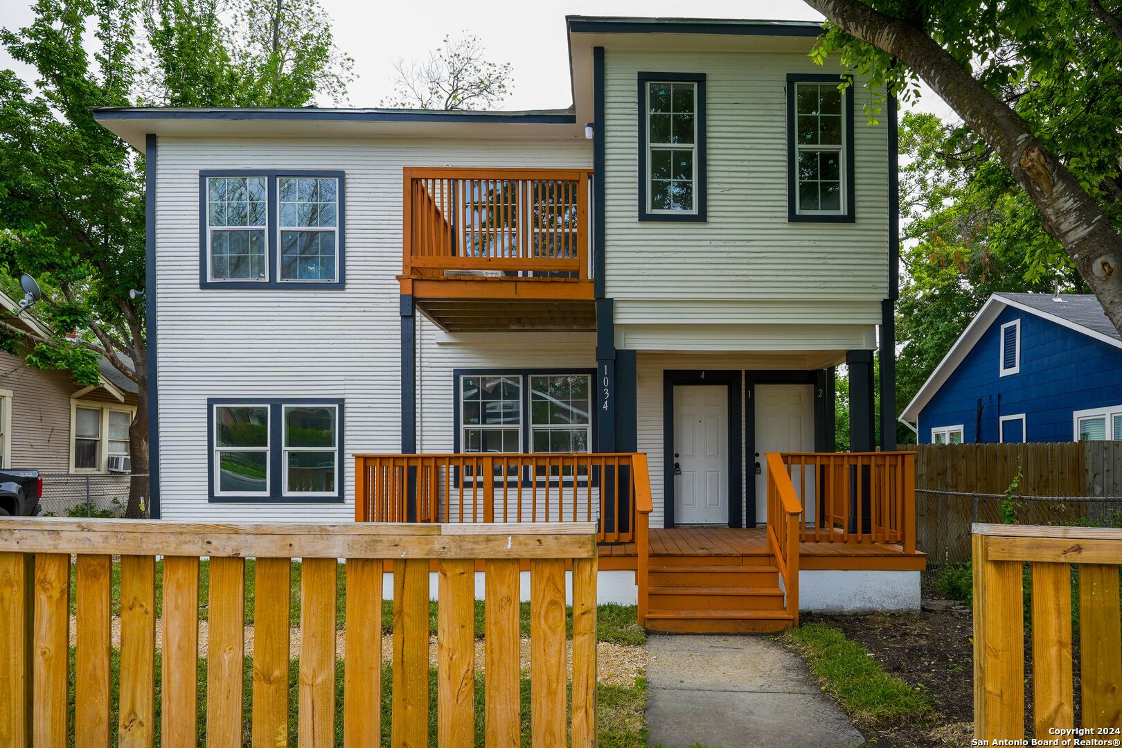 a view of a house with large windows and a small yard