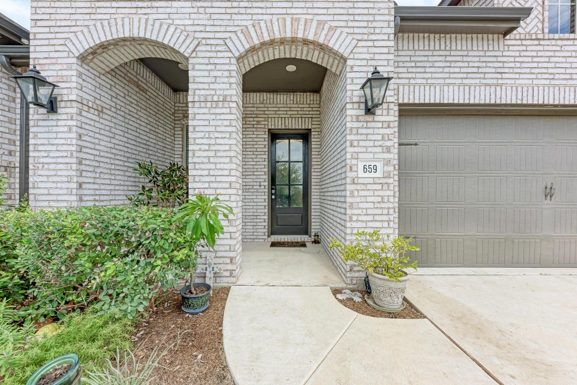 a front view of a house with potted plants