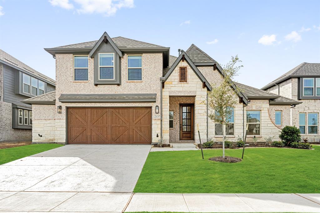 a front view of a house with a yard and garage