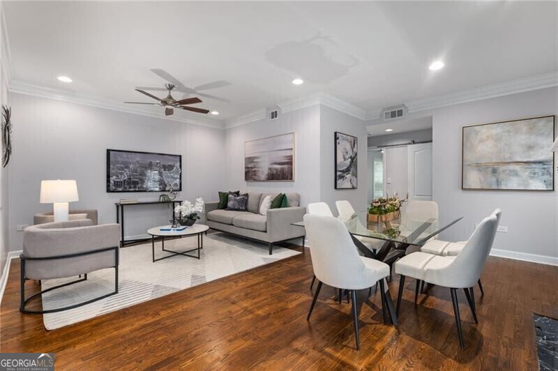 Dining area featuring ornamental molding, ceiling fan, hardwood / wood-style flooring, and a barn door