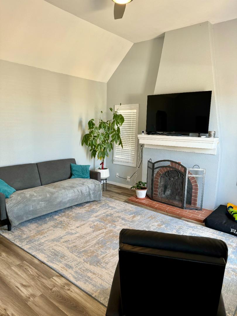 a living room with furniture a flat screen tv and a fireplace