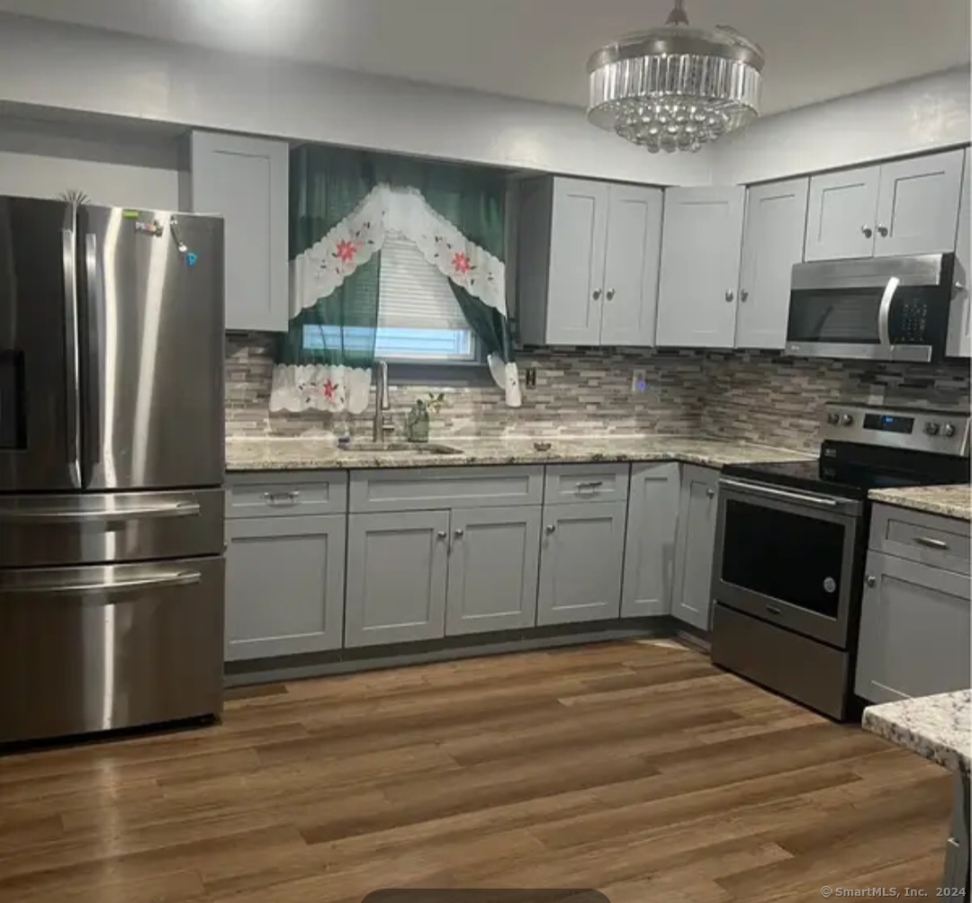 a kitchen with stainless steel appliances granite countertop a sink stove and refrigerator