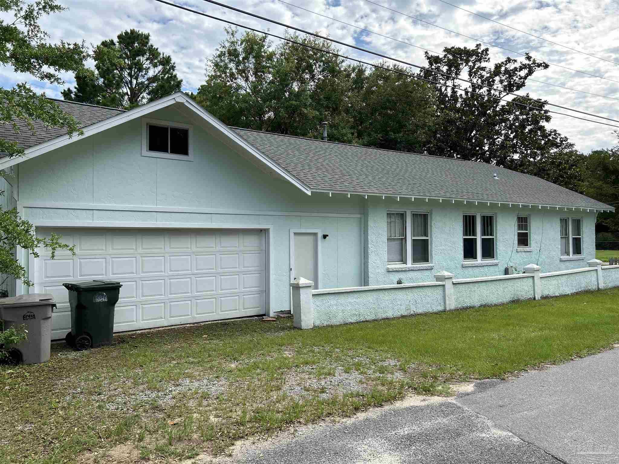 a front view of a house with a garden and yard