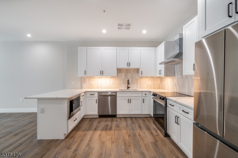 a kitchen with granite countertop white cabinets and white appliances