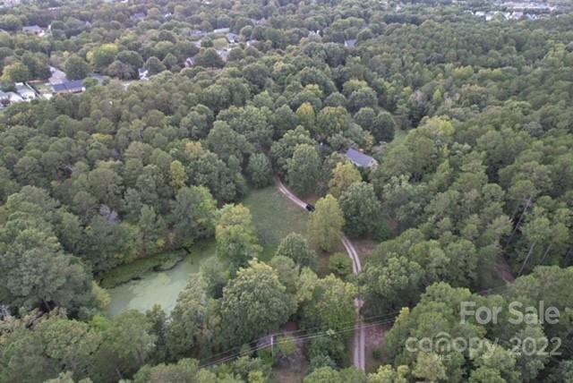 an aerial view of residential houses with outdoor space and trees