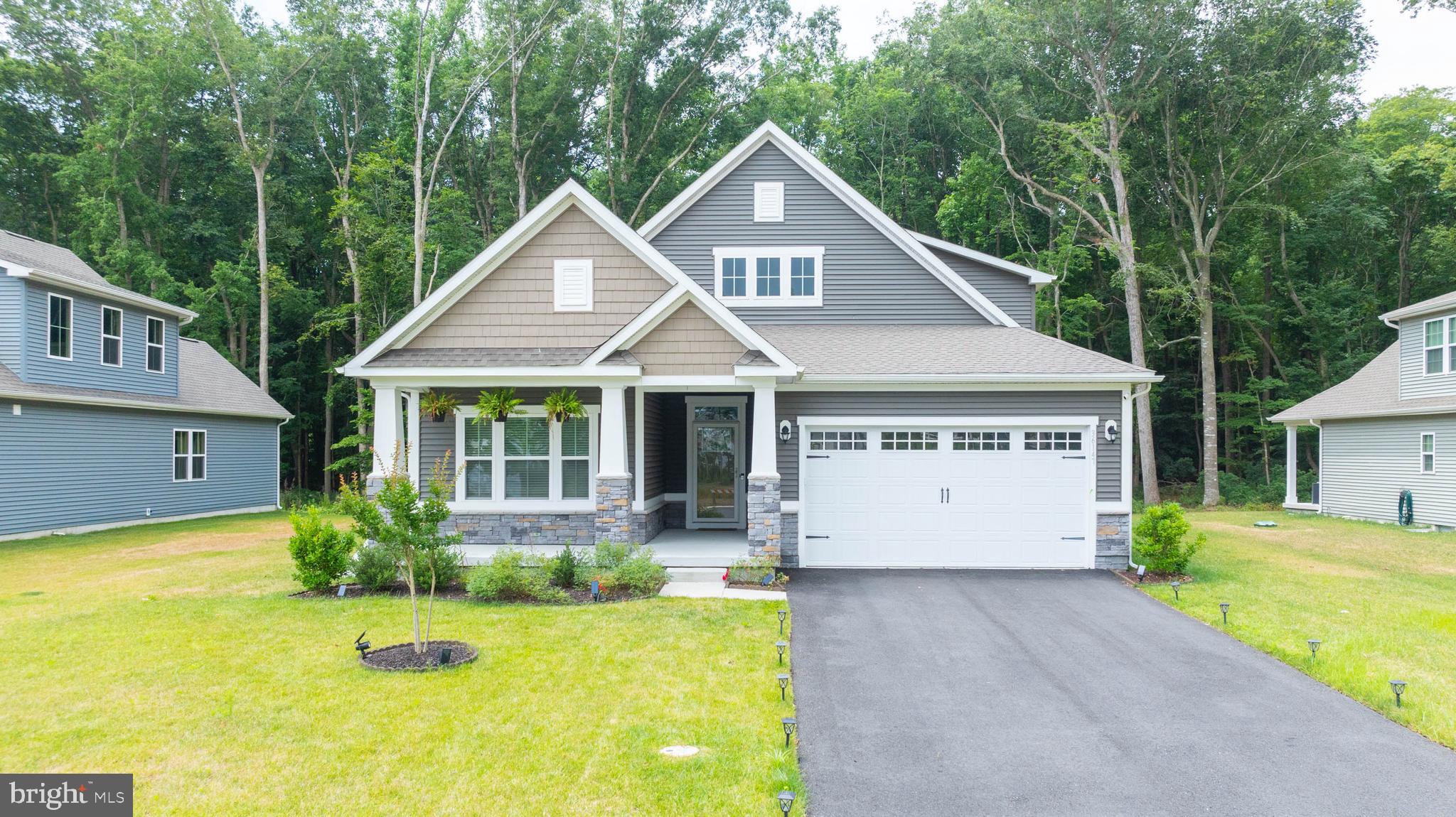 a front view of house with yard and trees in the background