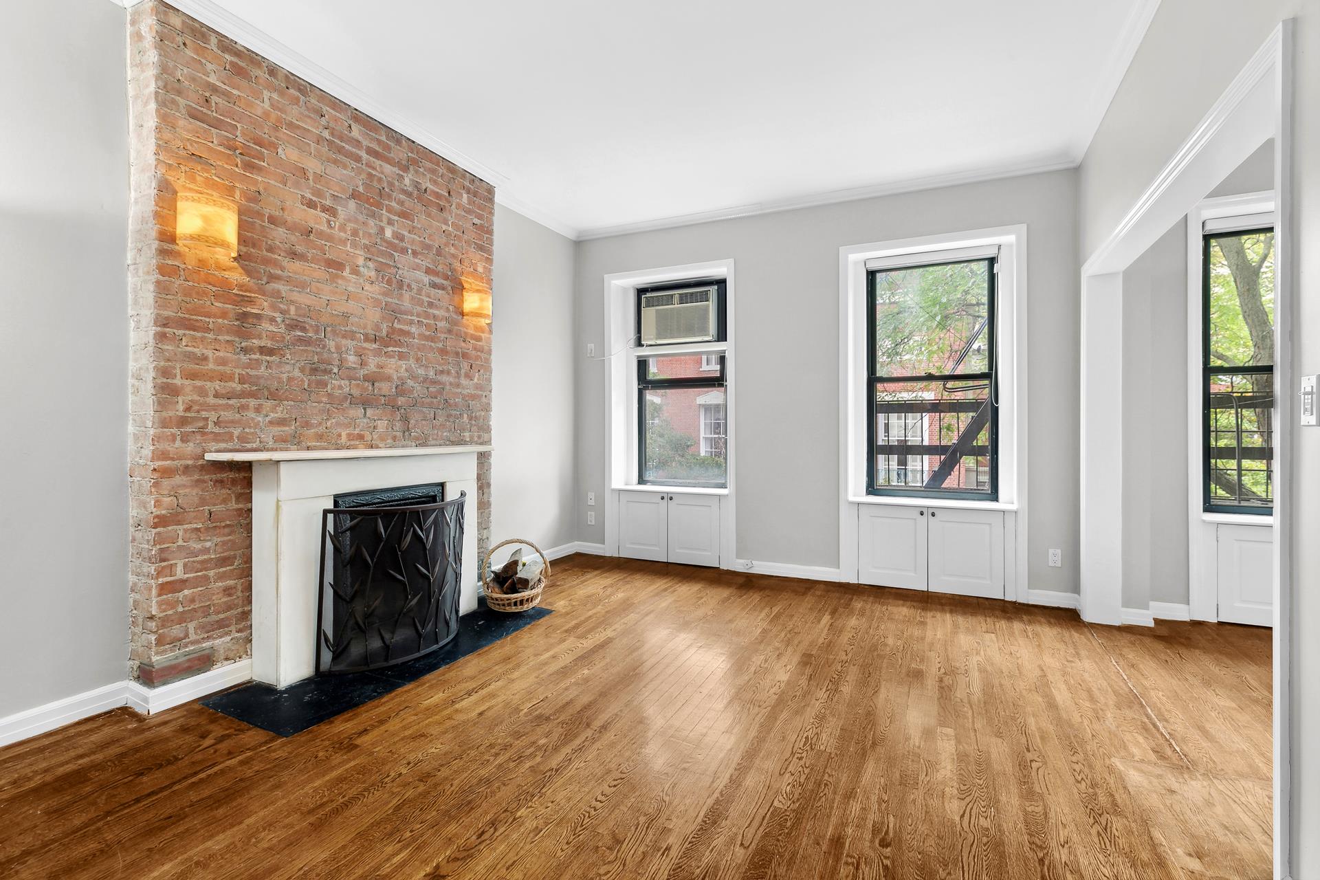 wooden floor fireplace and windows in an empty room