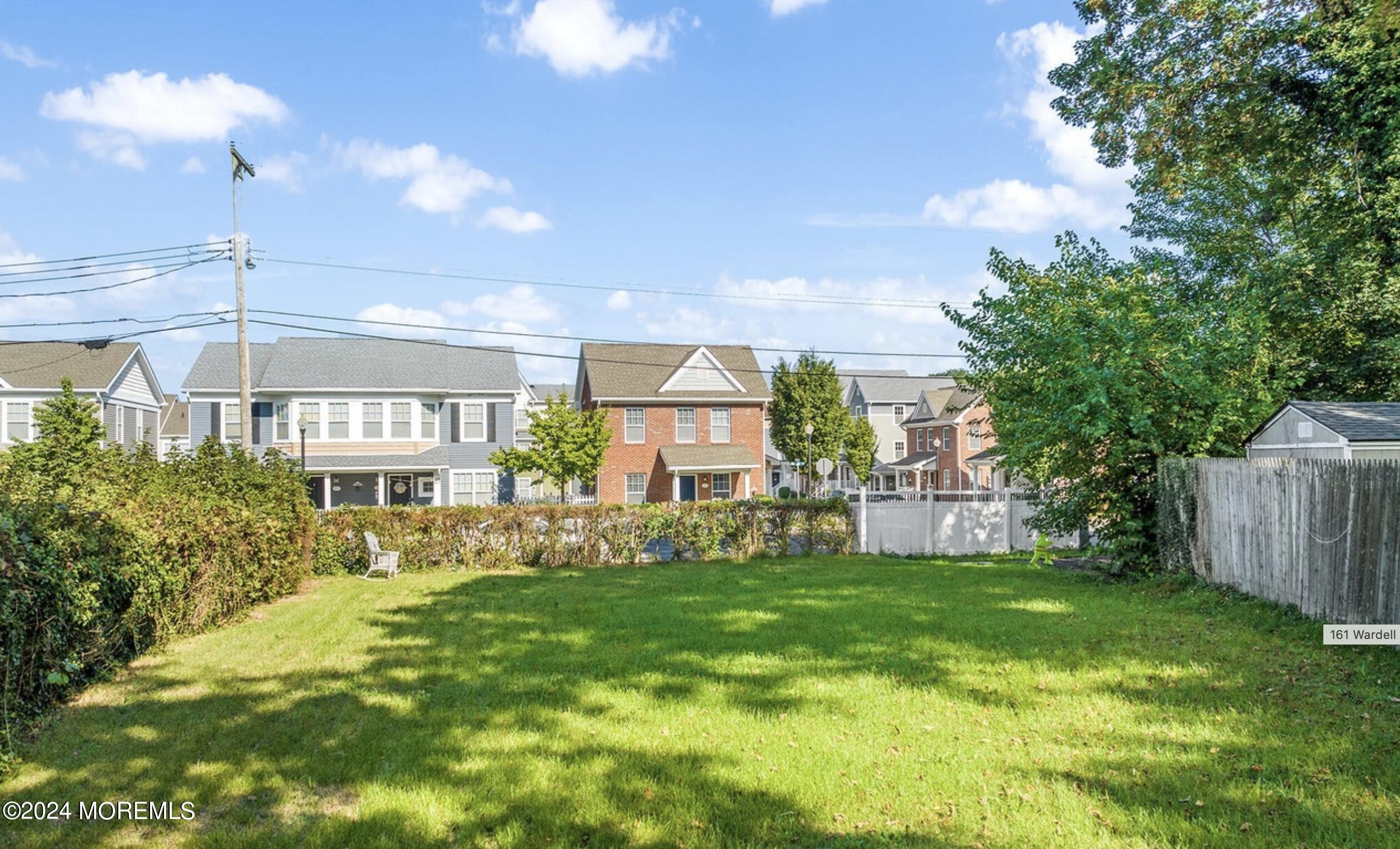 a view of a house with a big yard and large trees