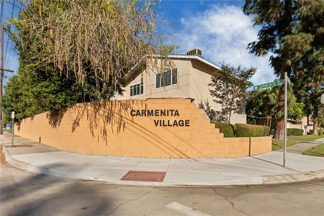 a sign board with buildings in the background