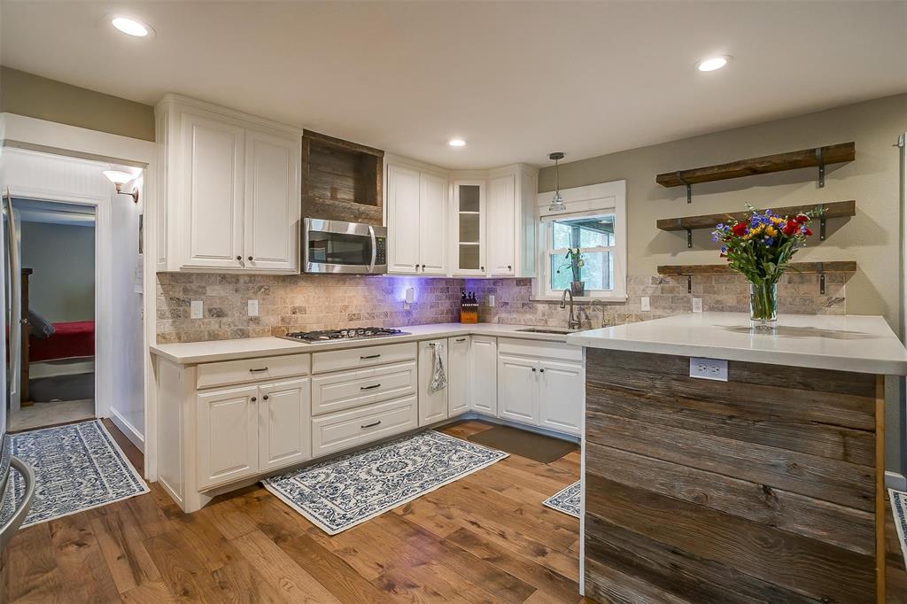 a kitchen with granite countertop a sink cabinets stainless steel appliances and a window