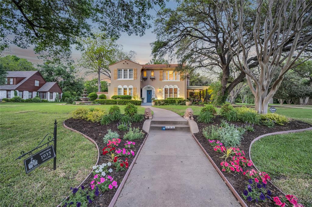 a front view of a house with a yard and fountain