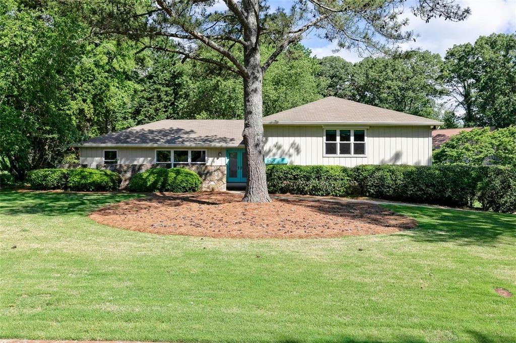 a front view of a house with yard and green space