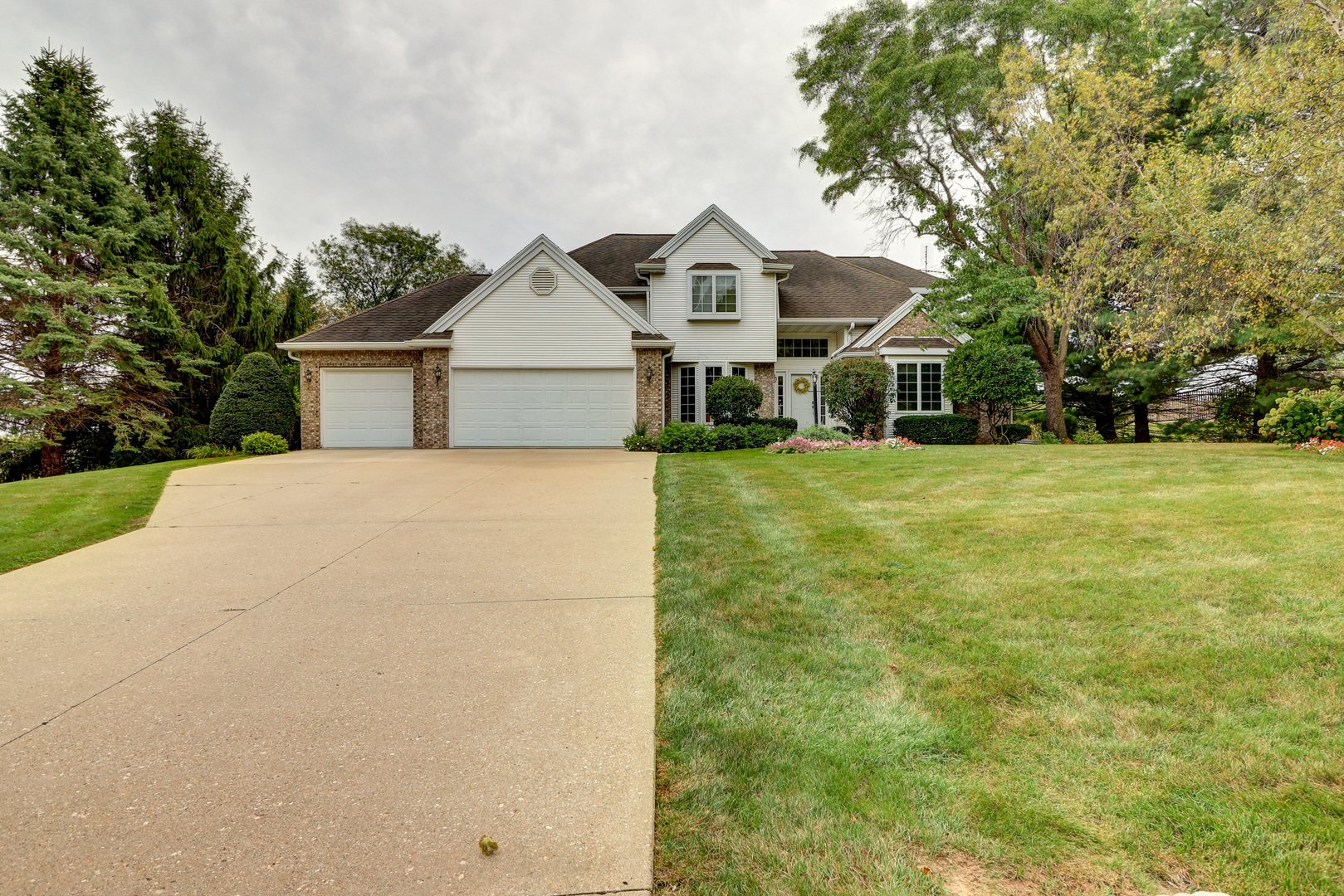 a front view of a house with a yard and trees