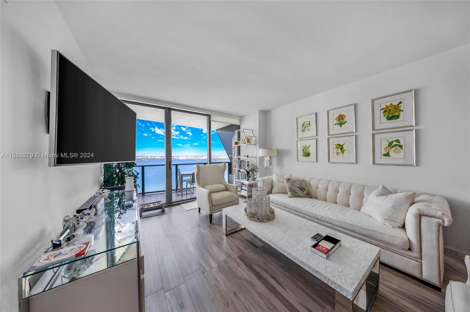 a living room with furniture flat screen tv and a large window