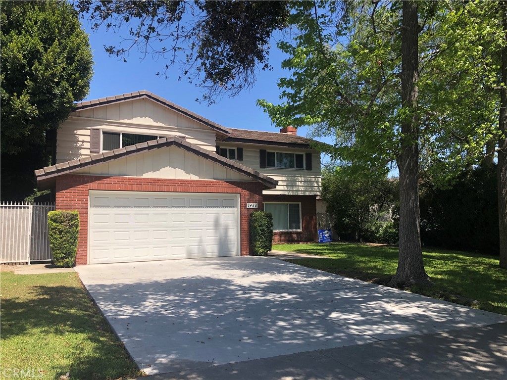 a front view of a house with a garden and trees