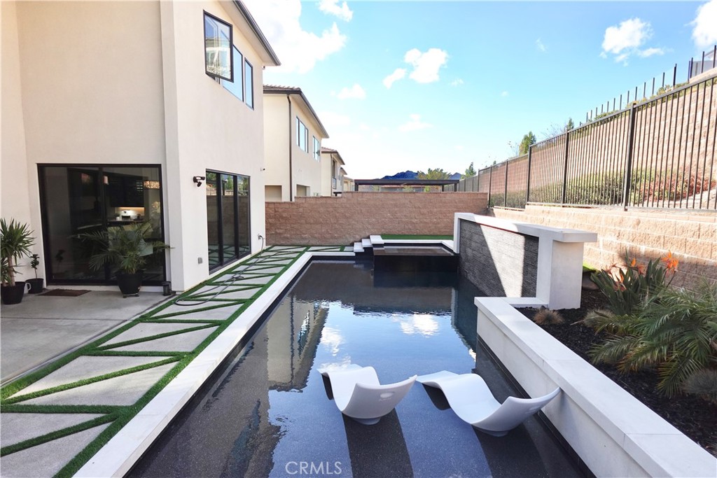 a view of a patio with couches table and chairs with wooden floor and fence