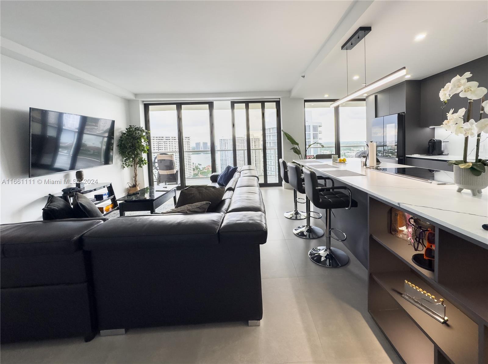 a living room with furniture a large window and a flat screen tv