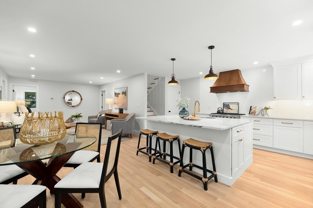 a very nice looking open dining room with kitchen island furniture a window and a sink