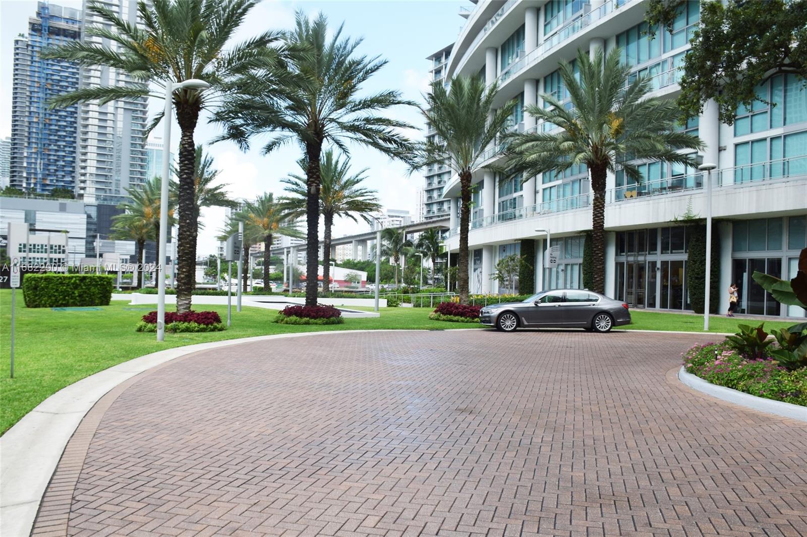 a view of a street with a building and palm trees