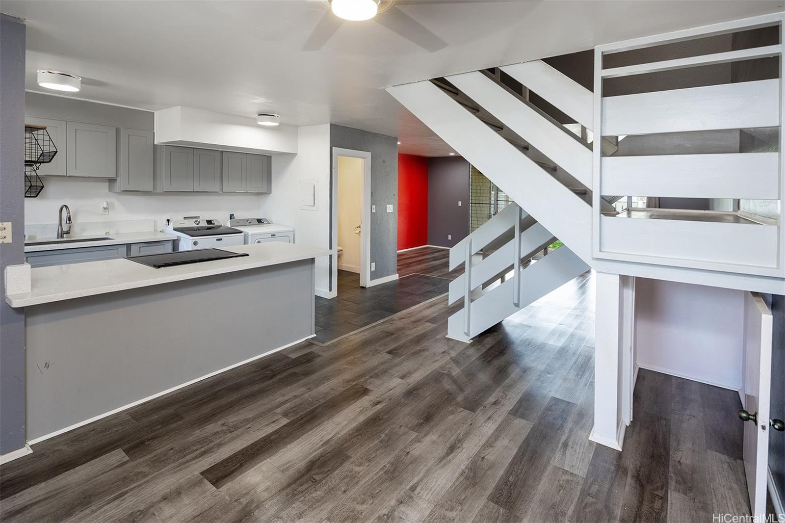 a kitchen with stainless steel appliances cabinets and a wooden floor