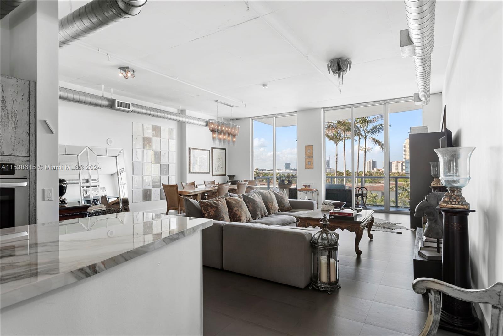 a living room with furniture large window and wooden floor