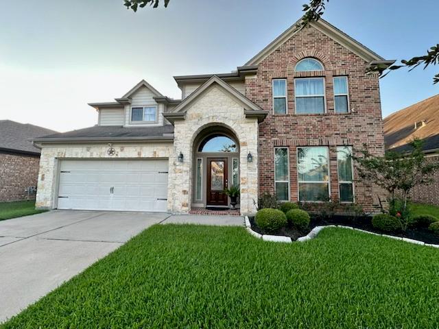 a front view of a house with a yard and garage