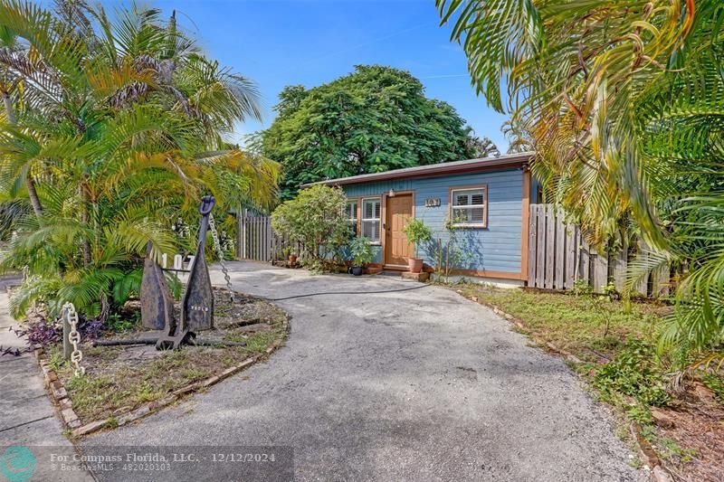 a view of a house with a yard and large tree