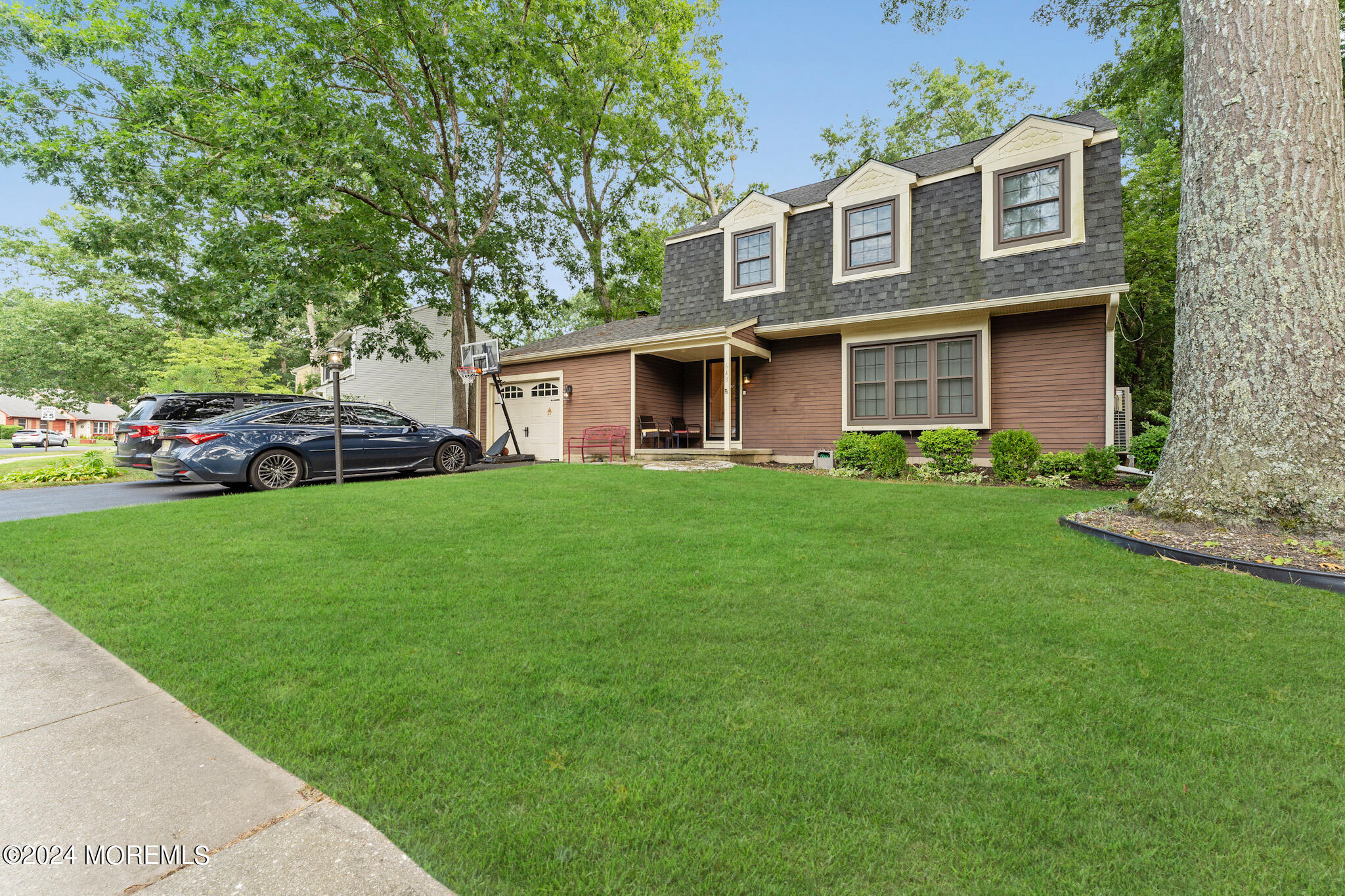 a front view of a house with a yard and trees