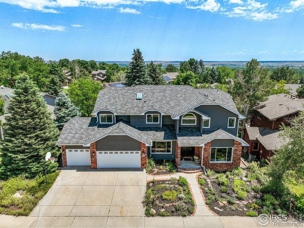 aerial view of a house with yard and trees in the background