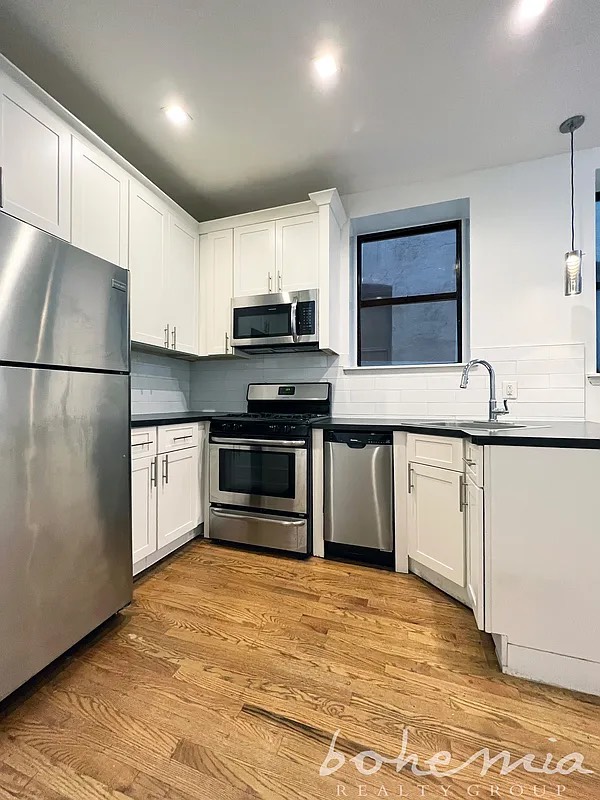 a kitchen with kitchen island granite countertop a stove a sink and a refrigerator