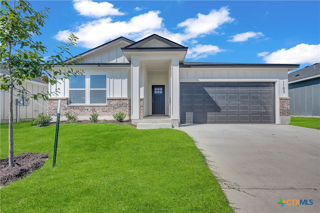 a front view of a house with a yard and garage