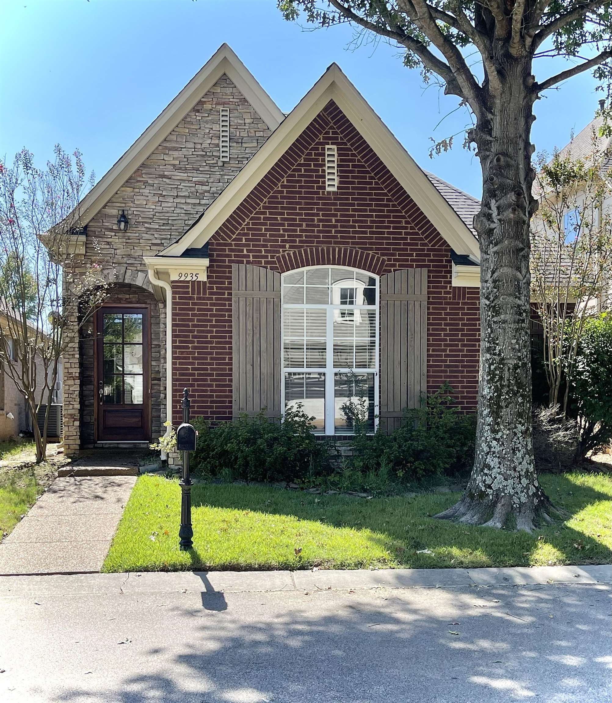 a view of brick house with a yard