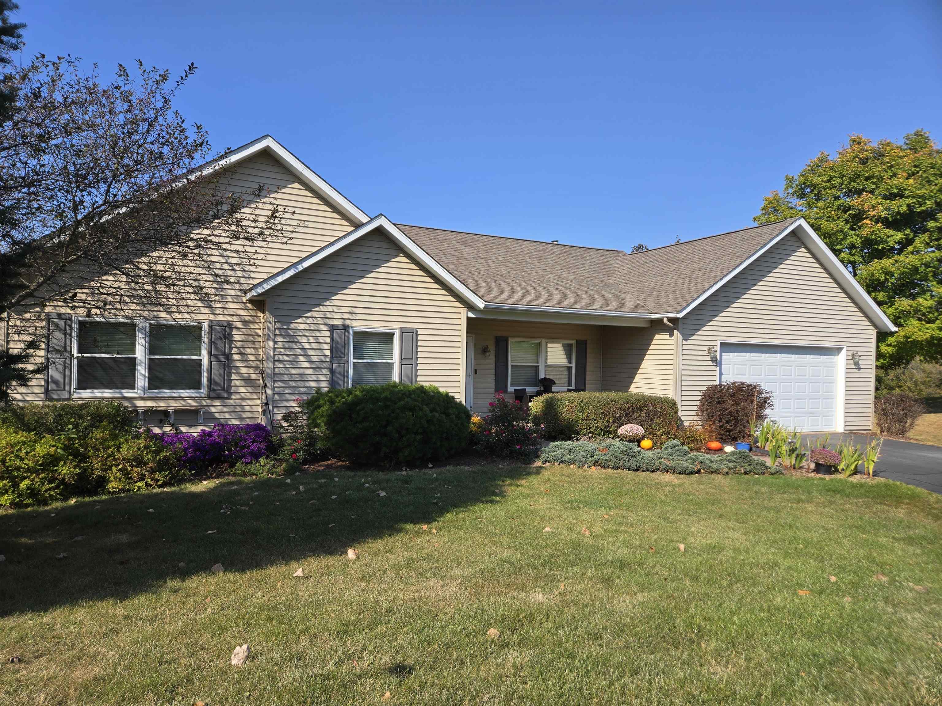 a front view of house with yard and trees in the background