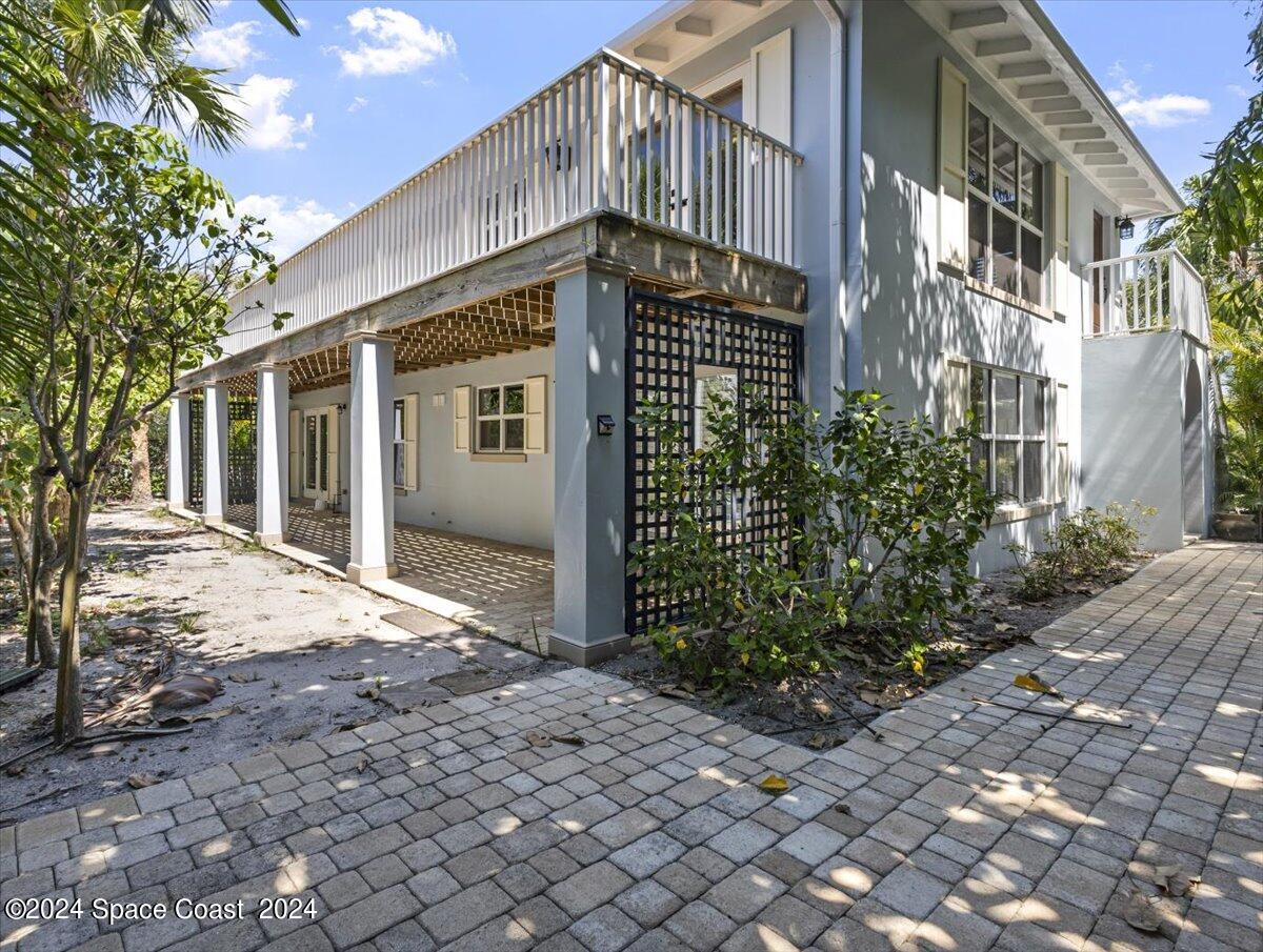 a front view of a house with a yard and potted plants