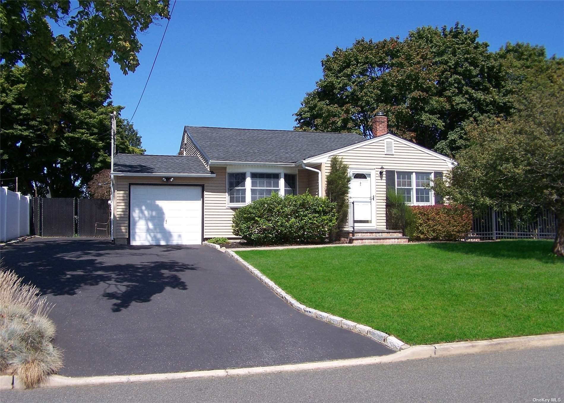 a front view of a house with yard and green space