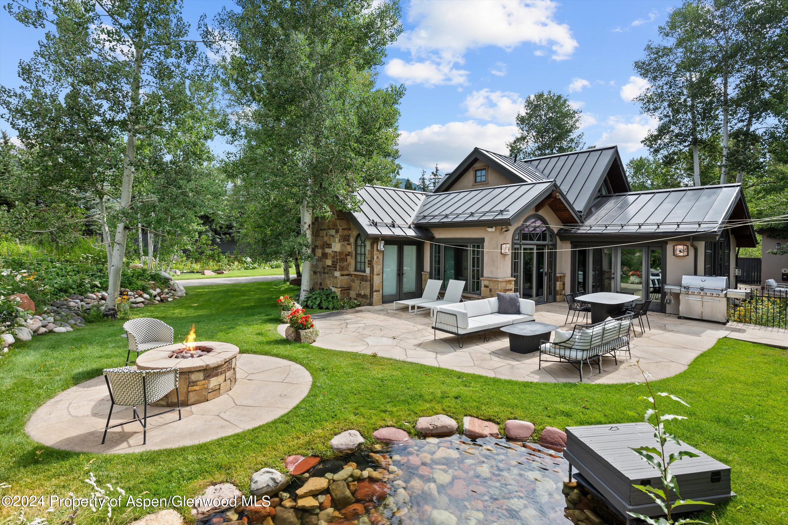 a view of a house with backyard sitting area and a garden