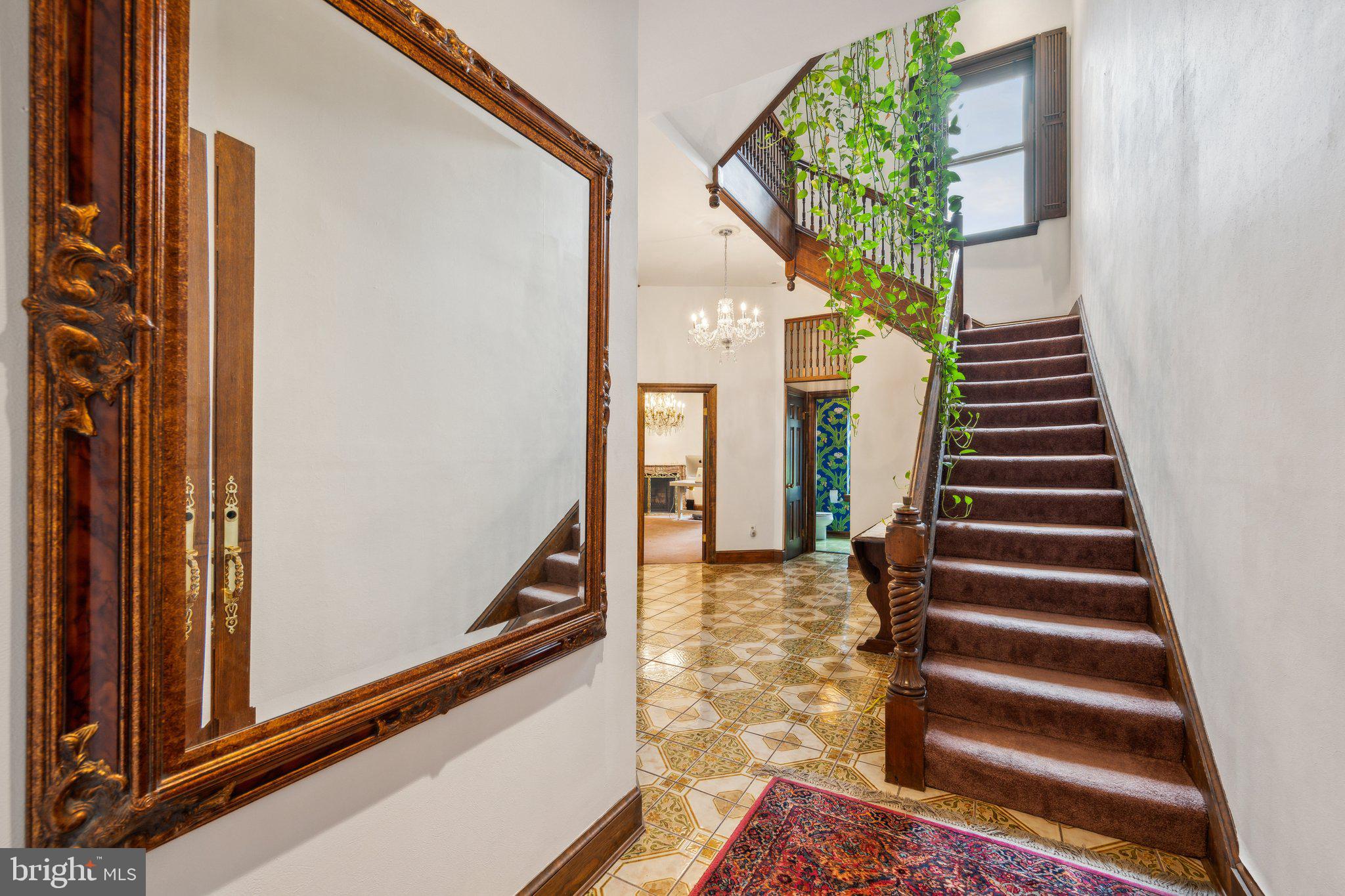 a view of a hallway with stairs and wooden floor