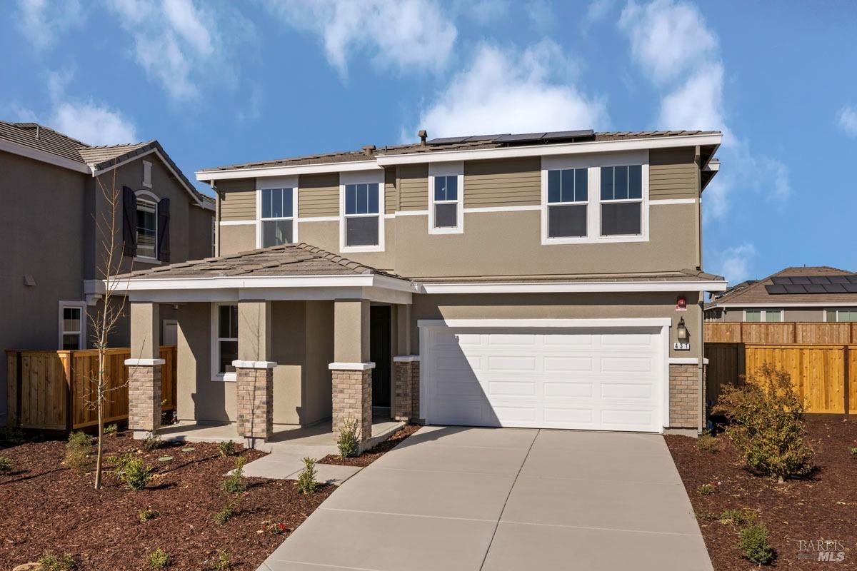 a front view of a house with yard and parking