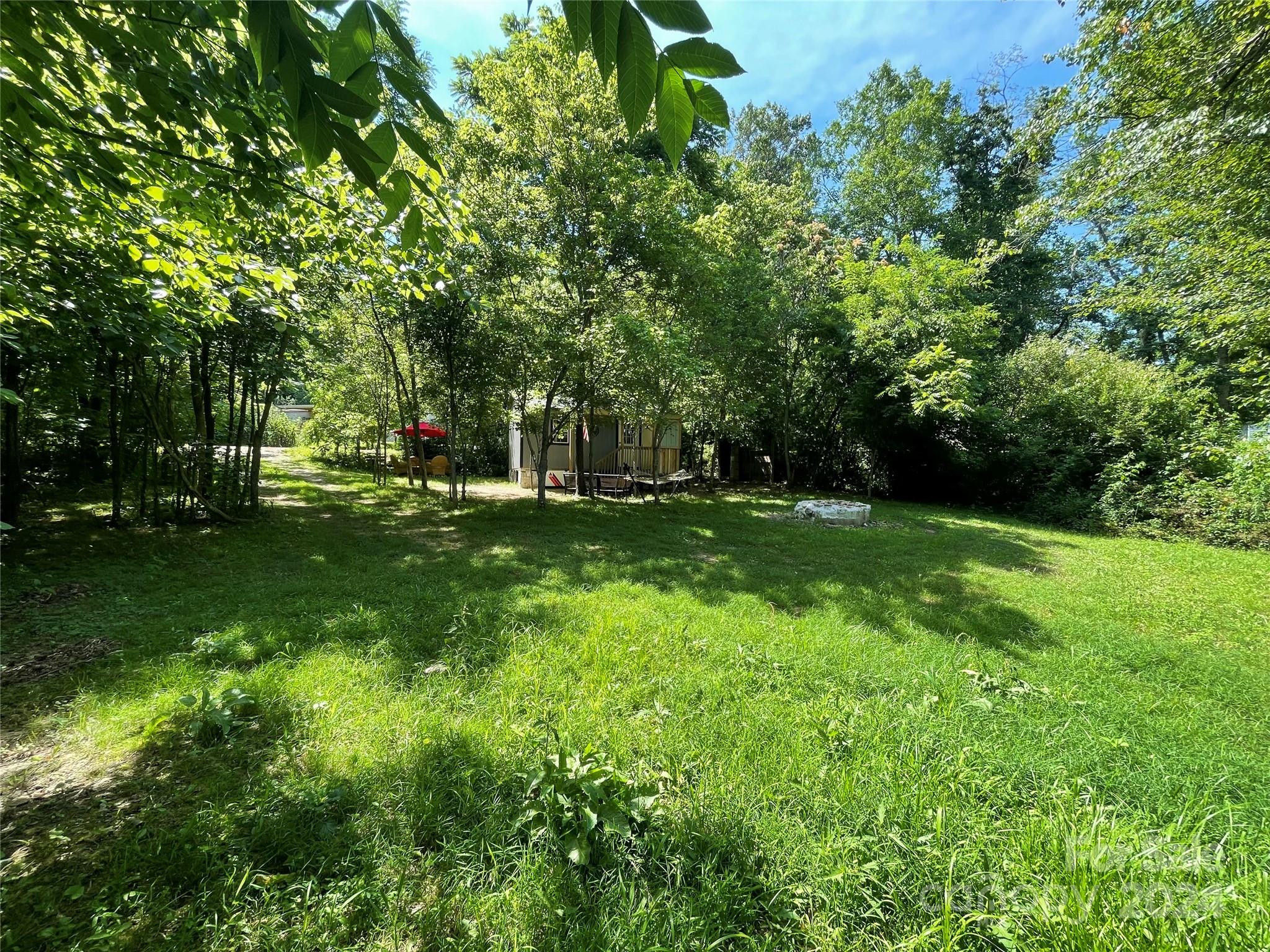 a view of green field with trees in the background