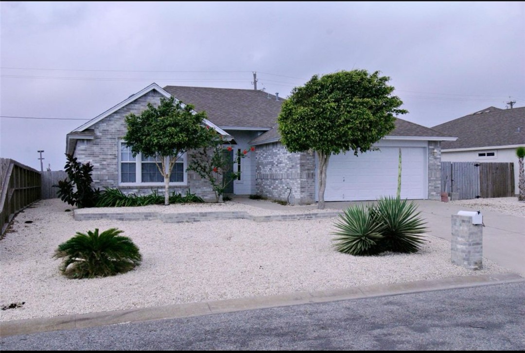 a view of a house with a yard and a garage