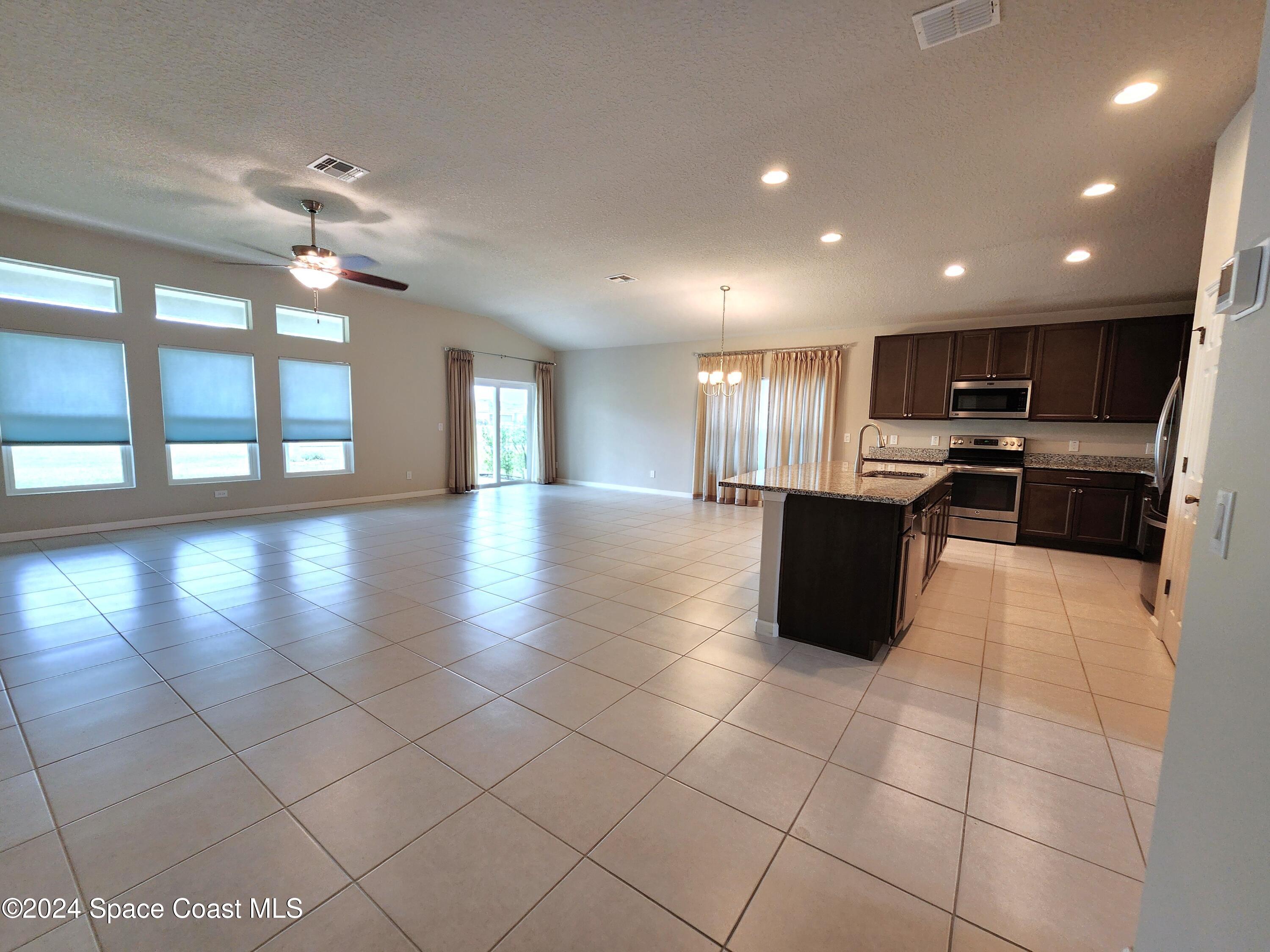 a large kitchen with stainless steel appliances granite countertop a sink and cabinets