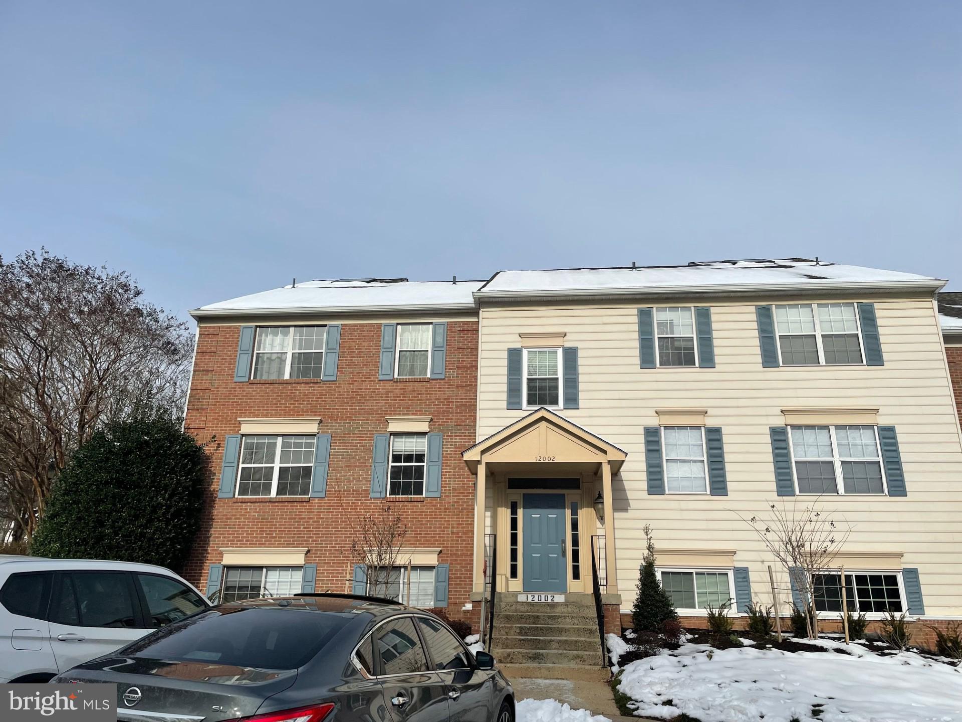 a front view of a house with cars parked