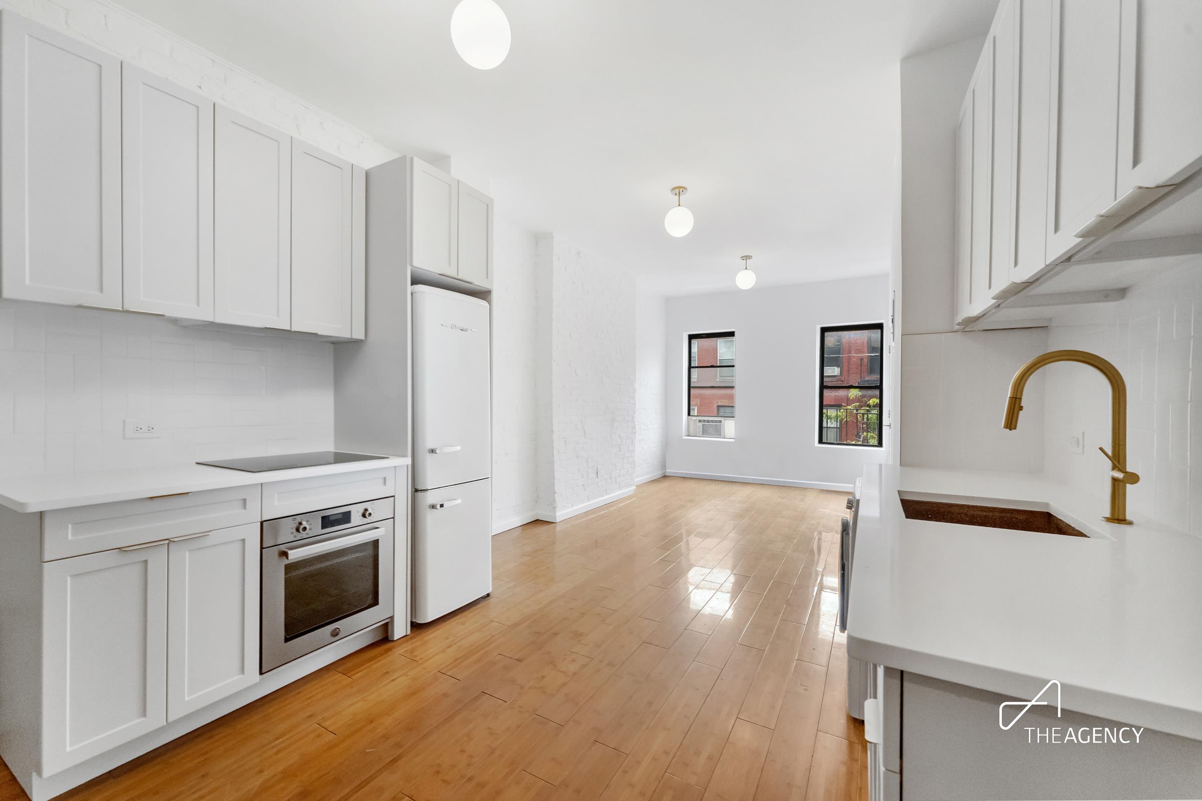 a kitchen with granite countertop white cabinets and stainless steel appliances