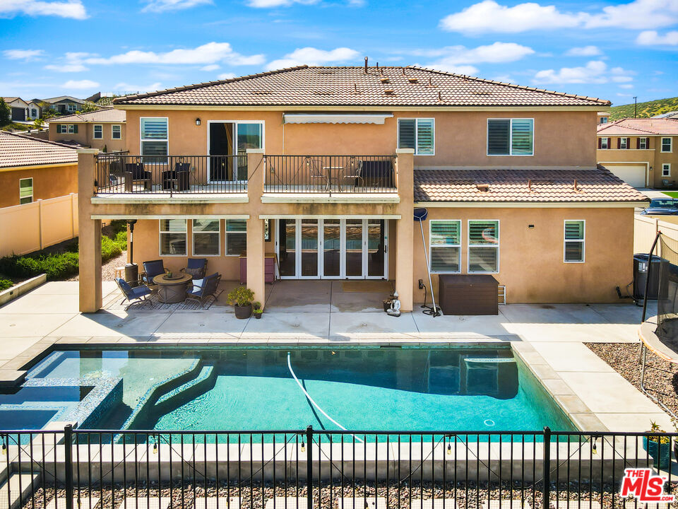 a view of a brick house with a patio and a yard