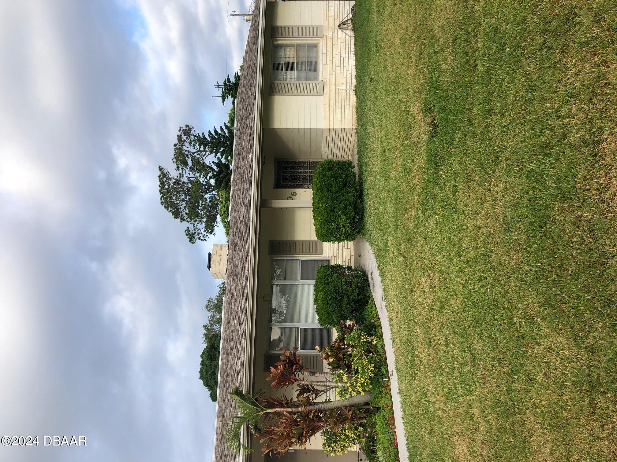 a front view of house with yard and green space