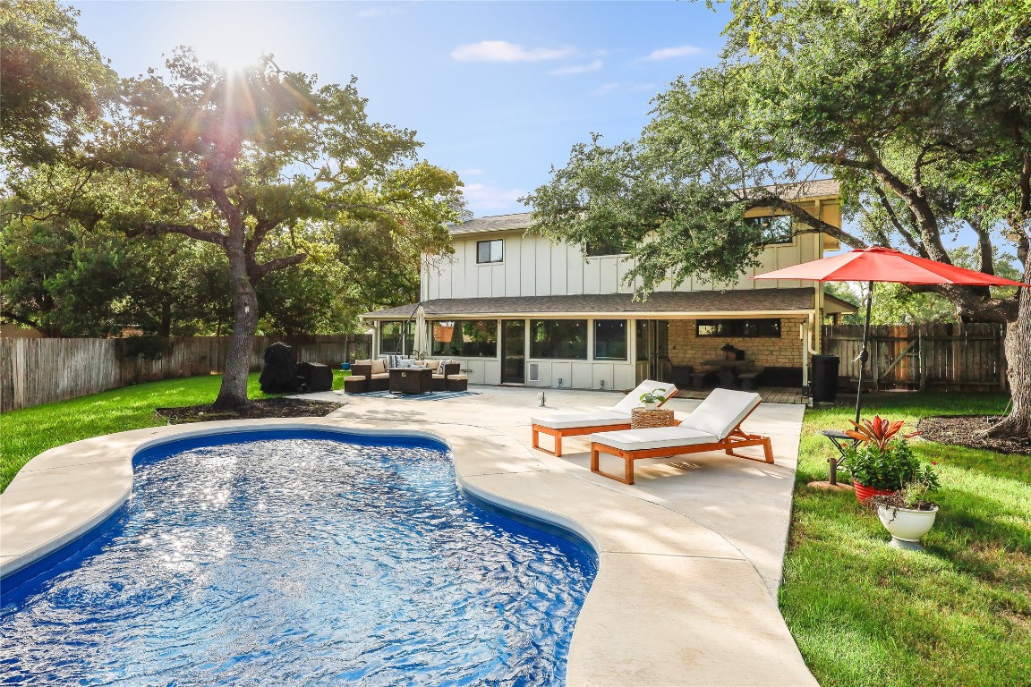 a view of a house with swimming pool and sitting area