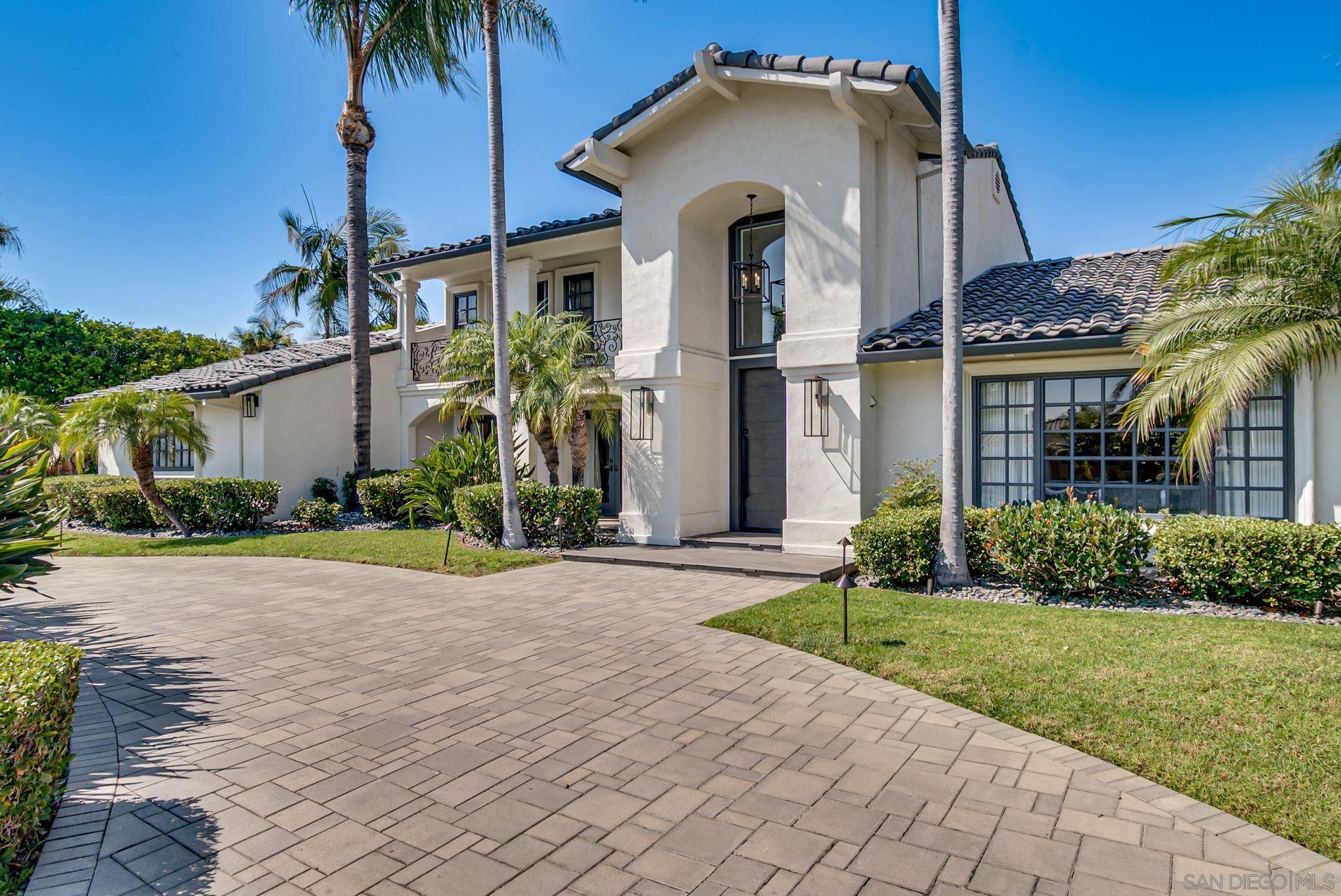 a front view of a house with a yard and potted plants